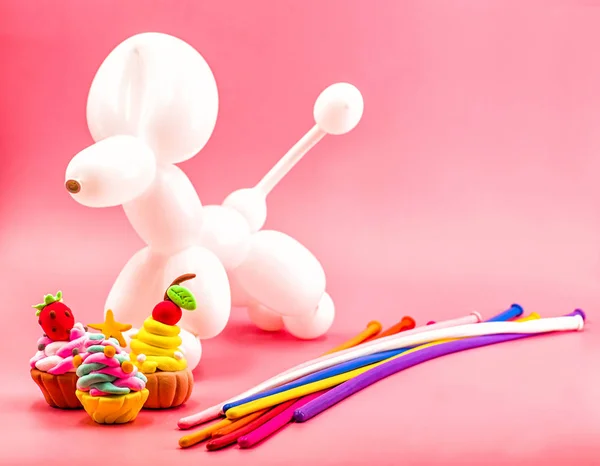 Party elements. party crafts. balloon dog, clay cupcakes and balloons on bright pink background — Stock Photo, Image