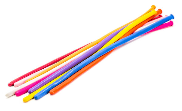 Куча разноцветных длинных шариков для скручивания без воздуха на белом фоне
