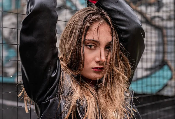 Bella donna in giacca nera in piedi accanto alla recinzione nel giorno di pioggia — Foto Stock