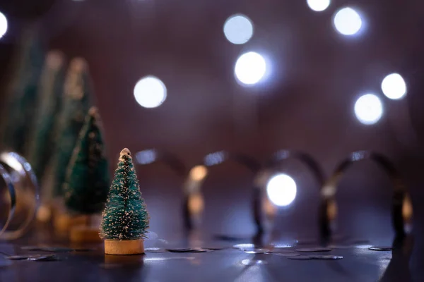 Christmas tree decorations standing in the line with fairy light — Stock Photo, Image