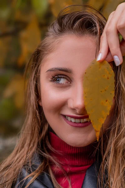 Bellissimo viso di una donna sorridente su sfondo foglie autunno con spazio copia — Foto Stock