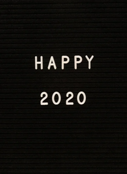 As palavras Feliz 2020 na placa de carta de feltro preto — Fotografia de Stock