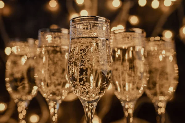 Copas de champán sobre fondo oscuro con luces —  Fotos de Stock
