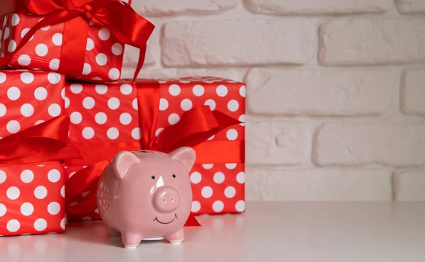 Stapel roter Geschenkboxen und Sparschwein auf weißem Wandhintergrund — Stockfoto