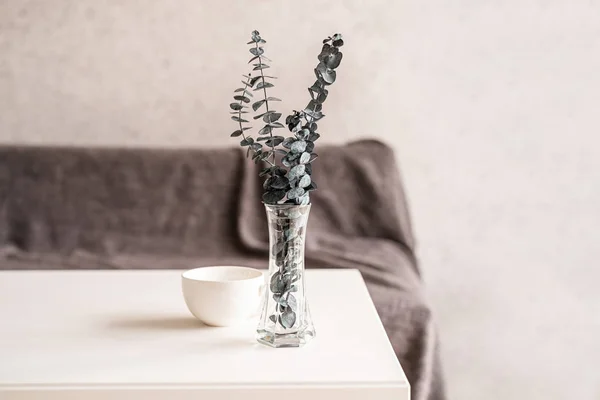 Eukalyptus in einer Vase mit einer Tasse Kaffee auf weißem Tisch — Stockfoto