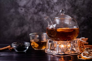 Koyu arkaplanda limonlu siyah çay demliği.