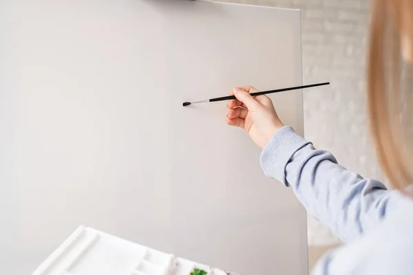 Female artist painting on the canvas in the studio — 스톡 사진