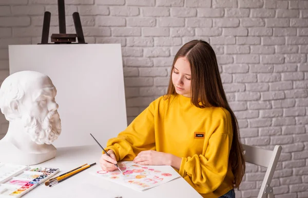 Female artist painting a picture with watercolor in the studio — ストック写真