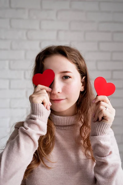 Портрет молодой женщины с красным сердцем на глазах — стоковое фото
