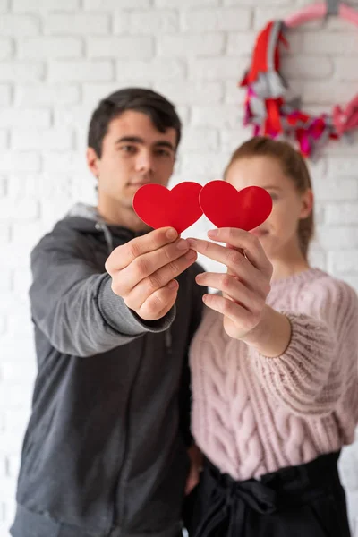 Pasangan muda yang bahagia memegang bentuk hati merah — Stok Foto