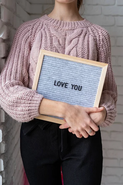 Молодая женщина с войлочной доской со словами "Люблю тебя" — стоковое фото
