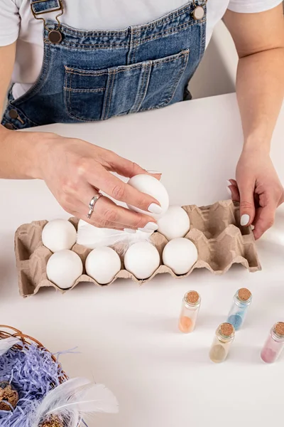 Manos de mujer sosteniendo un huevo blanco listo para la coloración de huevo de Pascua vista superior — Foto de Stock