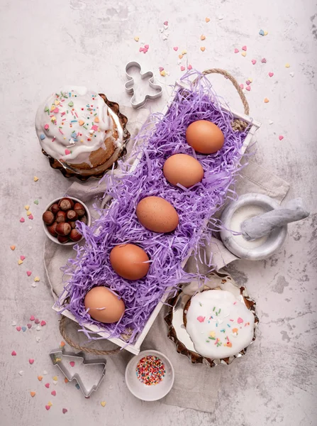 Ostereier in einer weißen Holzkiste mit glasierten Kuchen und Kochutensilien — Stockfoto