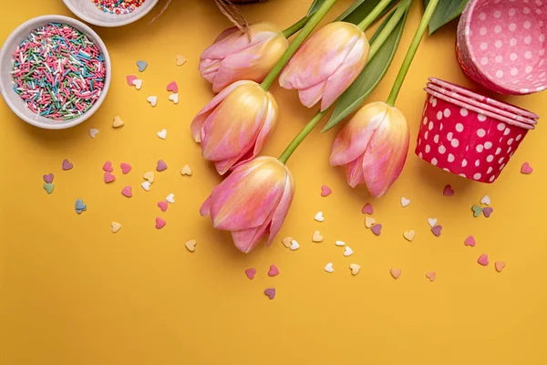 Torta di Pasqua con tulipani, uova e prodotti da forno vista dall'alto su sfondo giallo con spazio per copiare — Foto Stock