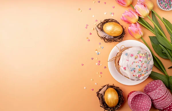 Paskalya pastası laleli, yumurtalı ve fırınlanmış ürünler turuncu arka planda fotokopi alanı ile üst görünüm