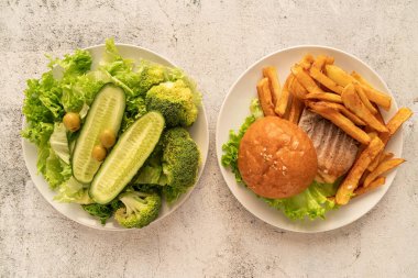 Sağlıklı ve sağlıksız gıda konsepti. Fast food tabakları ve sağlıklı yiyecekler.
