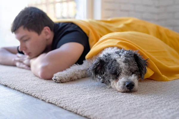 Joven durmiendo con su perro en el suelo — Foto de Stock