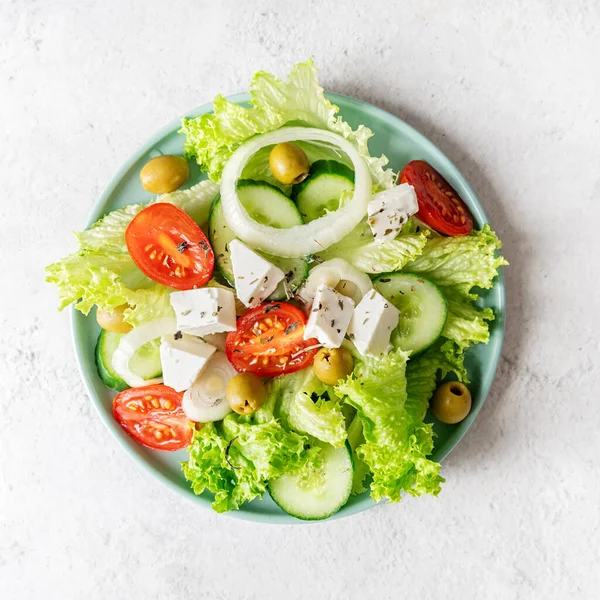 Görög saláta feta sajttal, friss zöldségekkel és olajbogyóval fehér rusztikus háttéren felülnézet négyzet alakú tájékozódás — Stock Fotó