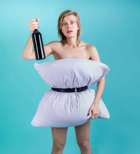 Coronavirus检疫疯狂的检疫 身穿枕衣的绝望女人手里拿着一个蓝色背景的酒瓶 枕头挑战 — 图库照片