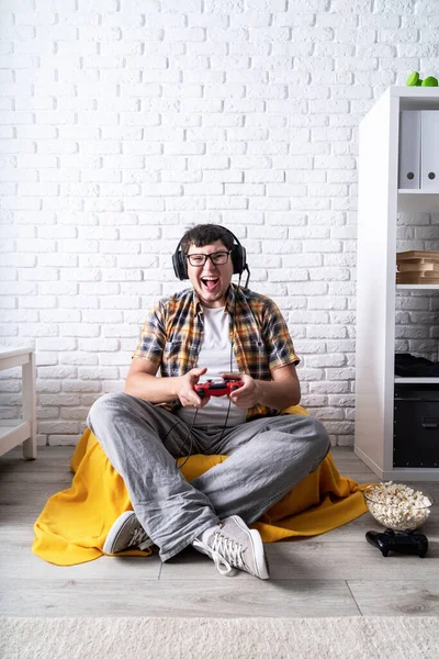 Podekscytowany młody człowiek gra w gry wideo w domu ciesząc się zwycięstwem — Zdjęcie stockowe