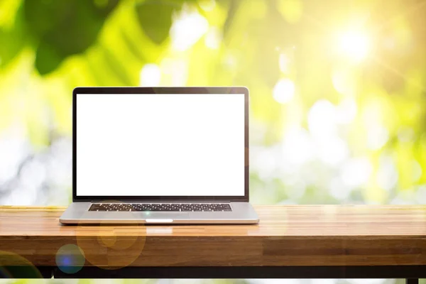 렌즈와 배경 흐리게 녹색 정원에서 나무 테이블에 노트북 빈 화면 플레어 로열티 프리 스톡 사진