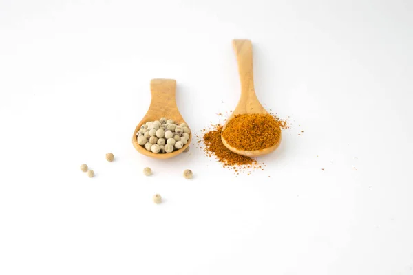 White pepper and paprika powder on wooden spoon on white backgro — Stock Photo, Image