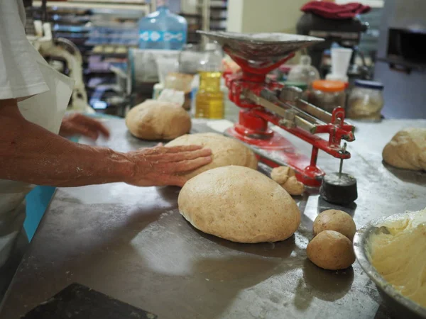 Adam çiğ hamurdan çörek yapıyor. Yerel bir fırında tatlı ekmek yapma süreci