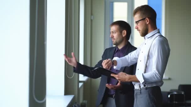 Zwei erfolgreiche Geschäftsleute haben im Büro am Fenster einen wichtigen Vertrag unterzeichnet — Stockvideo