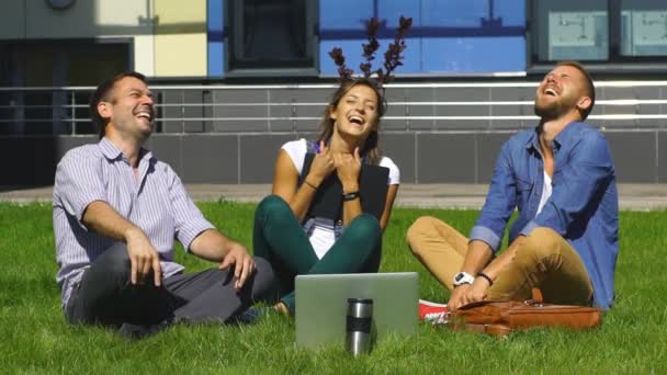 芝生と笑いの上に座って幸せな学生 — ストック動画