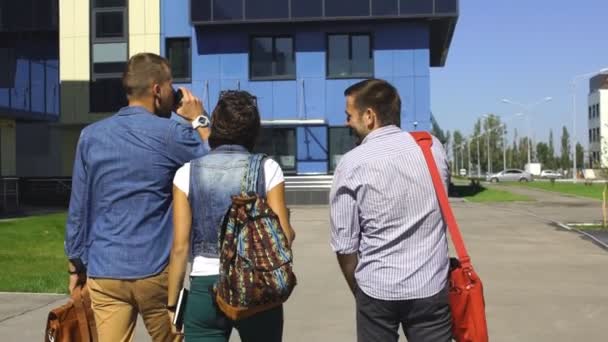 Vrolijke drie studenten aan het chatten bent in campus — Stockvideo