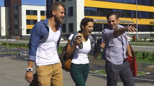 Junge Studenten zu Fuß vor dem Campus-Gebäude — Stockvideo