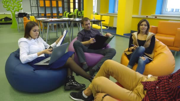 Cuatro estudiantes hablan en clase antes de la conferencia — Vídeo de stock