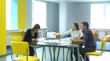 ofiste masasında otururken el sıkışan mutlu iş adamları