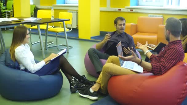 Cuatro estudiantes hablando en clase — Vídeos de Stock