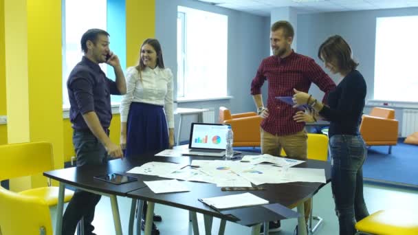 Pessoas de negócios felizes apertando as mãos enquanto sentado na mesa no escritório — Vídeo de Stock