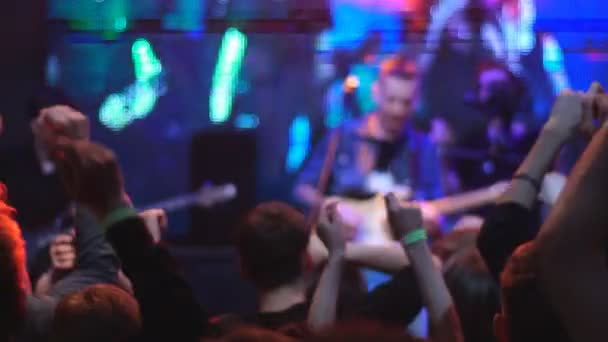 Togliatti, Rusia, 23 de abril de 2016: Audiencia con las manos levantadas en un festival de música y luces bajando desde arriba del escenario. Enfoque suave, alto ISO — Vídeos de Stock