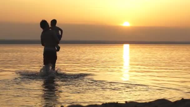 Silhuetter av far och son på sunset havet bakgrund — Stockvideo