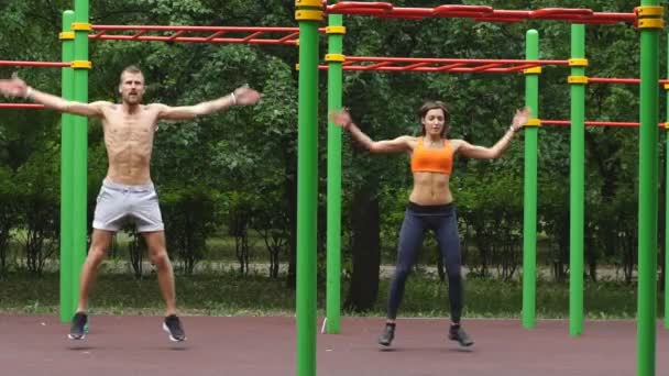 Cvičení - mladý pár skáčou dohromady — Stock video