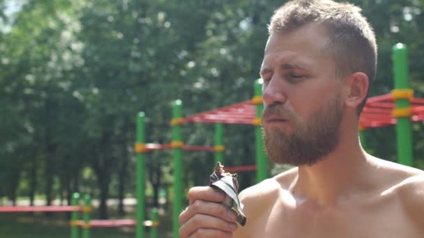 Fitness Man comiendo una barra de energía de chocolate — Vídeos de Stock