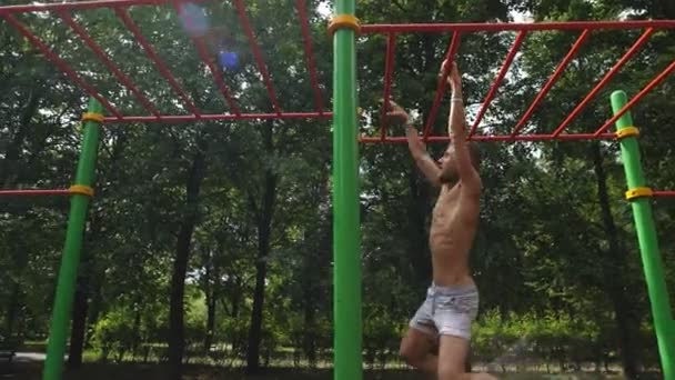 М'язистий чоловік робить витягування на горизонтальній панелі — стокове відео