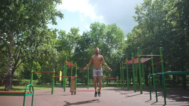 Young sport man exercising - jumping with skipping rope — Stock Video