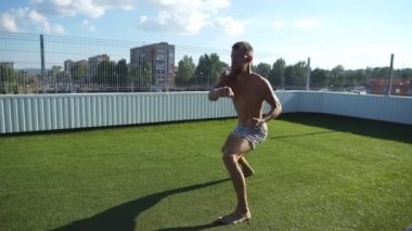 Deneyimli yoga master çeşitli yoga pozlar bir çatı üzerinde mavi gökyüzü gerçekleştirir.