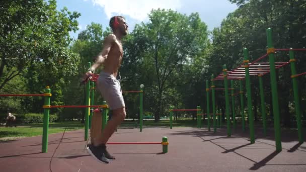 Sportif homme saut à la corde sur pelouse verte parc — Video