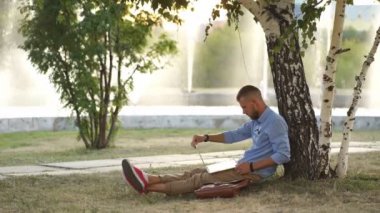 Adam parkta, oturma ile Laptop serbest çalışma yere oturmuş