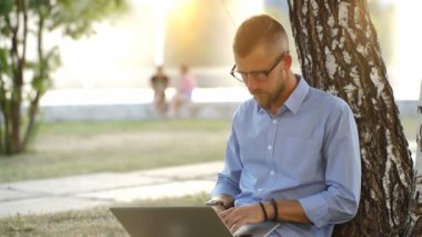 Adam parkta, oturma ile Laptop serbest çalışma yere oturmuş