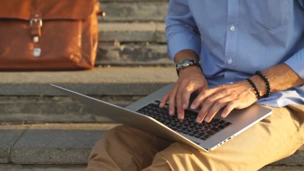 Detalhe de moderno hipster homem pés sentados nas escadas e usando laptop — Vídeo de Stock