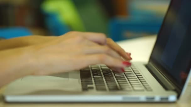 Detail z ženských rukou psát textovou zprávu na laptop uvnitř, mladá studentka, sedí na schodech knihovny a pomocí přenosného počítače — Stock video