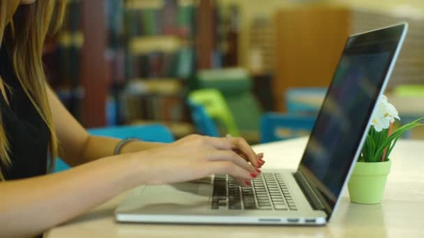 Närbild av ung kvinnlig student sitter på biblioteket trappan och använder bärbar dator — Stockvideo