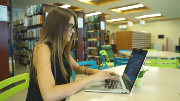 Mooie vrouwelijke student in een bibliotheek van de Universiteit — Stockvideo