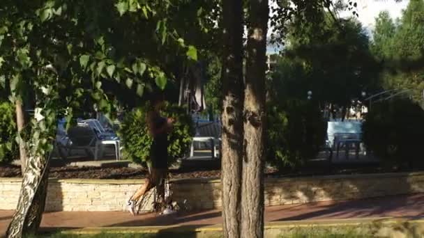 Schöne junge Frau spaziert im Sommer in einem Park — Stockvideo